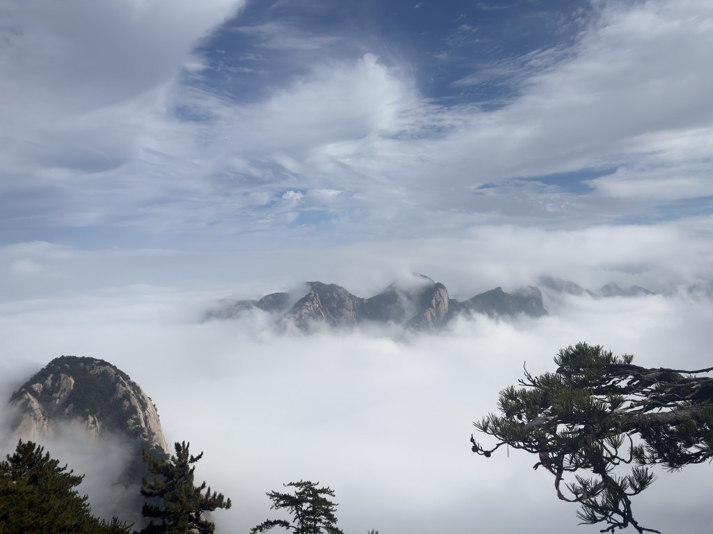 雲層覆蓋的山脈，藍天和白雲交織，顯示出壯麗的自然風景。