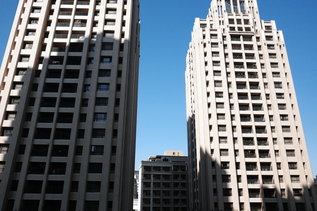 兩棟高樓大廈在藍天背景下，具有現代建築風格。